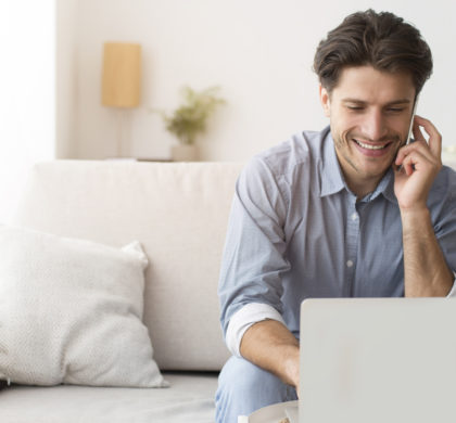 Always In Touch. Businessman Talking On Phone Working On Laptop At Home. Free Space