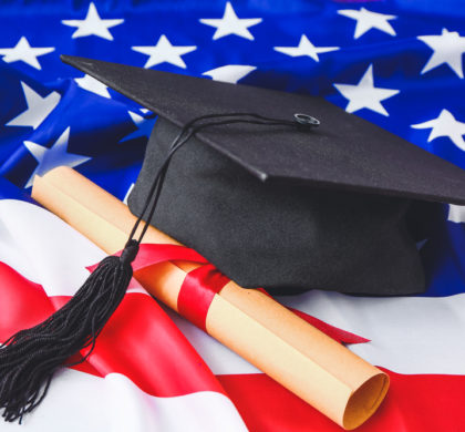 Graduation hat and diploma on USA flag