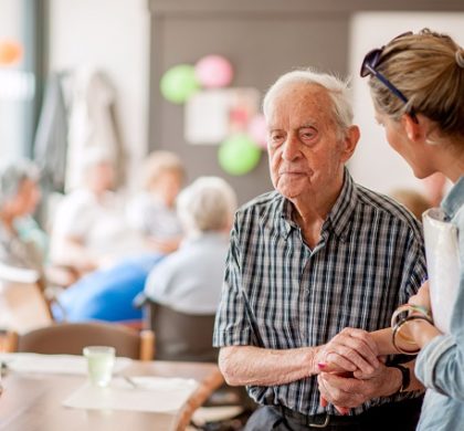 Assistant In The Community Center Giving Advice To A Senior Man