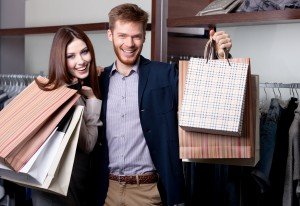 Cheerful couple show their purchases after shopping