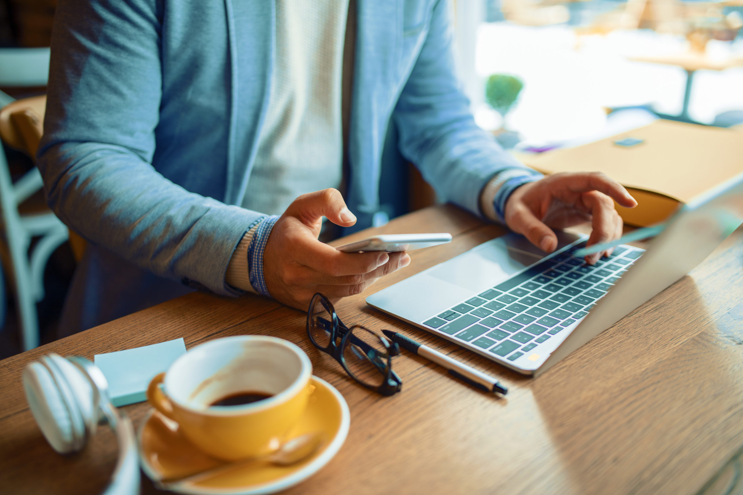 Businessman having coffee and doing his work in cafe. Close up concept.